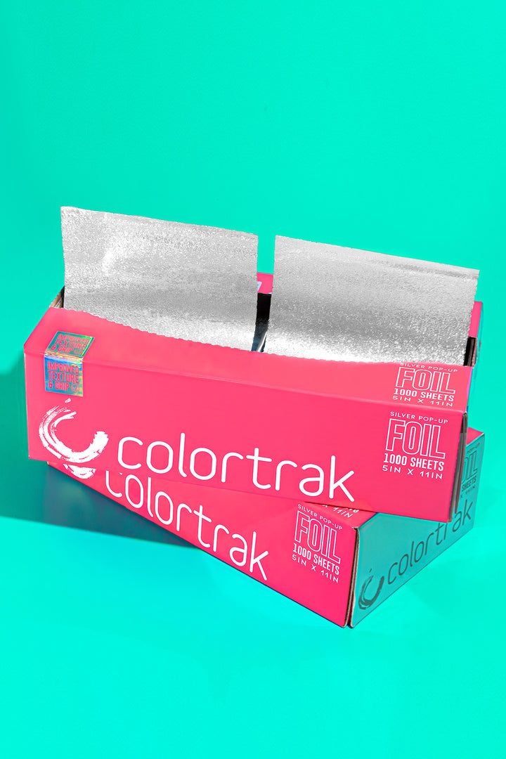 Pink 1000 sheet foil box at an angle on a teal background, with silver sheets popping up from both slots
