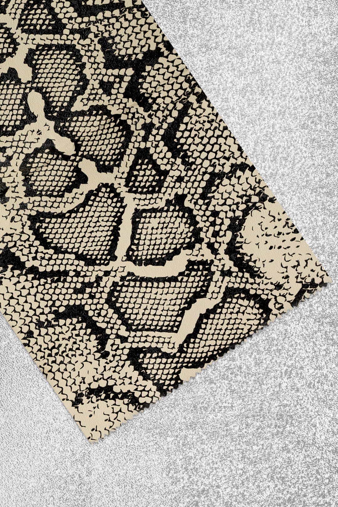 Foil sheet folded back to show the print up close: black and cream python snakeskin scales. Plain silver on the reverse side.