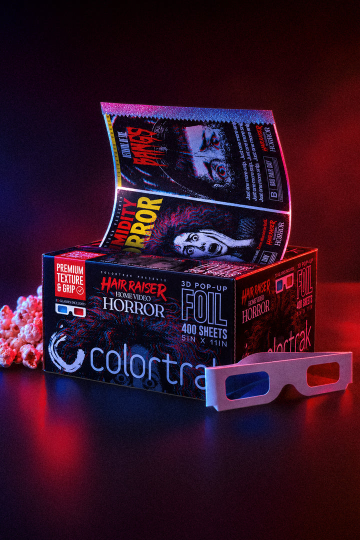 Hair Raiser foil box and 3D glasses in dramatic red and blue lighting, with a printed sheet rising from the box