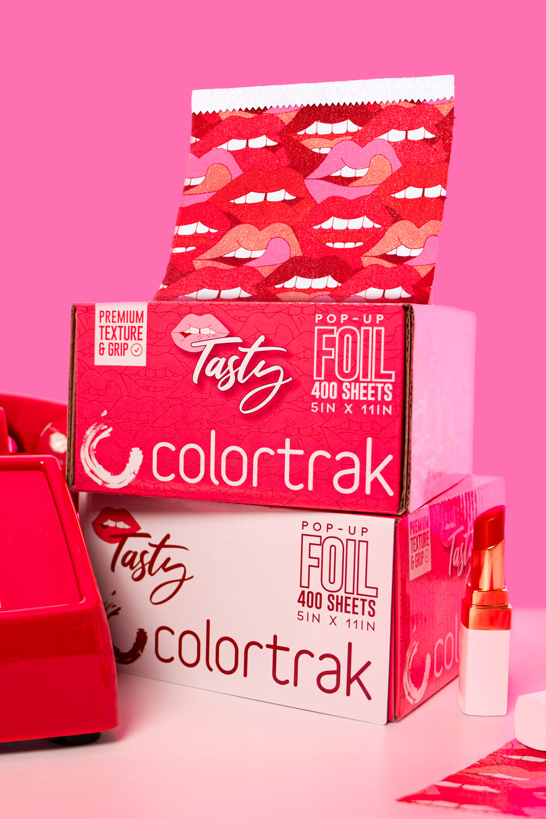 Stacked Tasty foil boxes on a pink background, with a printed sheet popping up from the top
